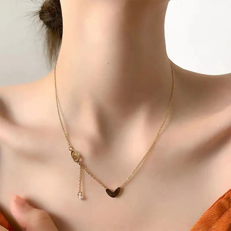 Gold-toned love heart necklace, titanium steel women's jewelry, double-sided pendant necklace, fade-proof adjustable chain, light luxury accessory, minimalist collarbone chain, hypoallergenic necklace, fashionable gift idea, versatile daily wear, sustainable materials, affordable elegance, artisan crafted, positive energy jewelry, modern feminine style, special occasion gift, holistic wellness accessory, cultural inspired design, elegant packaging.