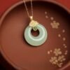 Close-up of Green Jade Lucky Coin Pendant with gold cloud accent