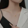Close-up of woman wearing Interlocking Heart Necklace with black top