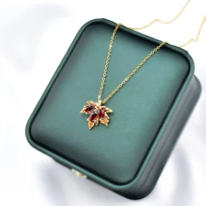 Gold Maple Leaf Necklace with Red Gemstones on Leather Jewelry Box