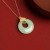 S925 Sterling Silver Lucky Coin Necklace with Light Green Jade on red dish