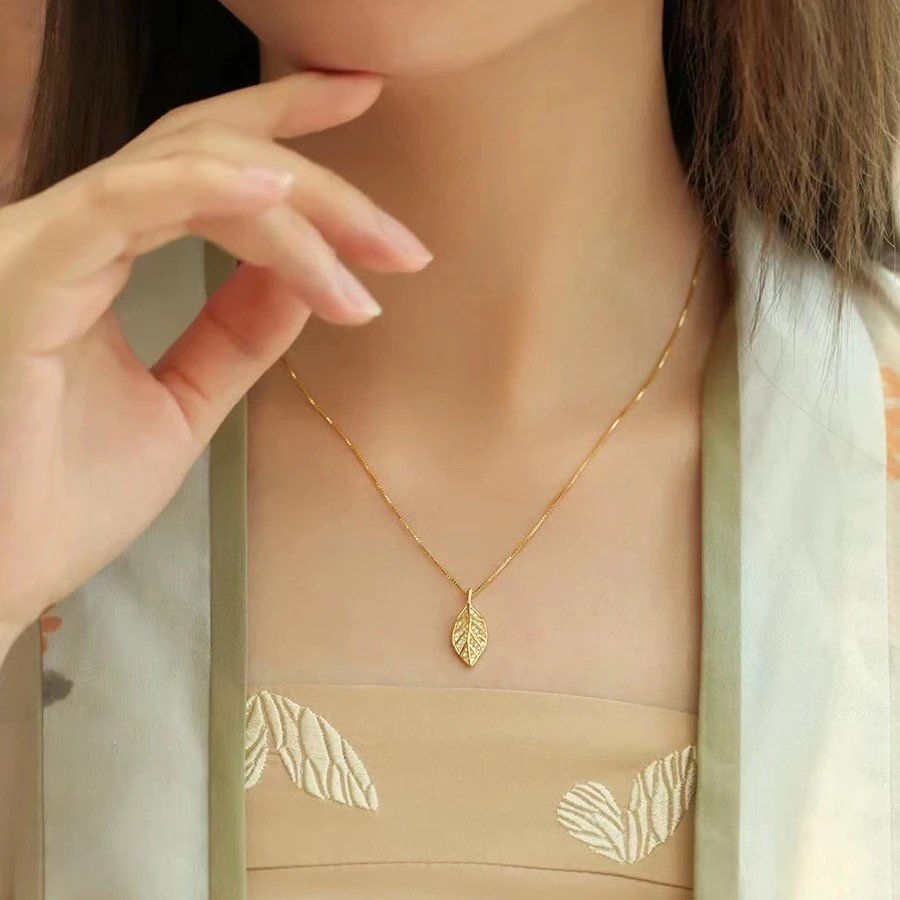 Titanium steel leaf necklace, synthetic zircon pendant, niche style jewelry, light luxury collarbone chain, adjustable necklace for women, hypoallergenic fashion accessory, versatile daily wear, sweet and elegant gift, sustainable materials, affordable luxury, artisan crafted, positive energy accessory, modern feminine style, cultural inspired design, holistic wellness jewelry, special occasion gift, minimalist jewelry, layering piece, elegant packaging.