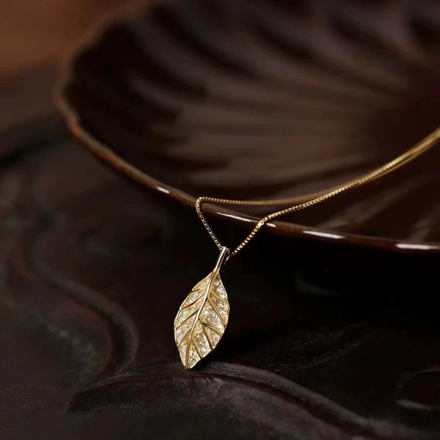 Titanium steel leaf necklace, synthetic zircon pendant, niche style jewelry, light luxury collarbone chain, adjustable necklace for women, hypoallergenic fashion accessory, versatile daily wear, sweet and elegant gift, sustainable materials, affordable luxury, artisan crafted, positive energy accessory, modern feminine style, cultural inspired design, holistic wellness jewelry, special occasion gift, minimalist jewelry, layering piece, elegant packaging.