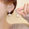 Woman holding Pearl and Zircon Earrings with pink pearl