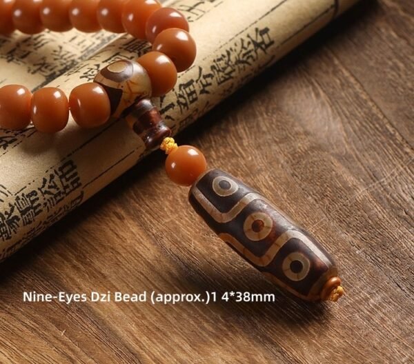 108-bead Buddhist mala, honey-colored prayer beads, natural seed necklace, meditation necklace, spiritual protection pendant, eye motif mala, handmade Buddhist jewelry, mindfulness accessory, Zen lifestyle gift, eco-friendly spiritual tool, unisex mala necklace, prayer beads for meditation, traditional mala design, earthy tone jewelry, calming energy beads, Buddhist ritual accessory, durable natural beads, minimalist spiritual wear, gift for yoga practitioners, authentic mala necklace.