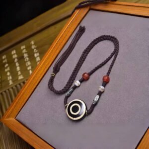 Blessed Tibetan dzi bead necklace, Eye of Wisdom amulet, hand-knotted rope necklace, spiritual protection jewelry, Tibetan cultural necklace, agate bead accessories, meditation talisman, authentic dzi bead jewelry, symbolic charm necklace, Himalayan craft necklace, energy balancing jewelry, sacred gift idea, unique spiritual accessory, traditional knotting technique, vintage-inspired talisman, daily wear spiritual jewelry, enlightenment symbol necklace, mystical jewelry, holistic lifestyle accessory, meaningful jewelry for seekers.