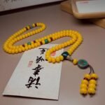 Golden yellow bead bracelet, statement bohemian jewelry, red and green accent beads, turquoise pendant bracelet, tassel bead bracelet, artisanal ethnic jewelry, luxury handmade bracelet, eye-catching designer jewelry, boho chic accessory, festival wear bracelet, unique pendant jewelry, cultural inspired bracelet, gift for jewelry lovers, unisex statement piece, elegant beaded bracelet, versatile layering bracelet, spiritual symbolism jewelry, high-quality artisan craft, bold color jewelry, ethnic fashion accessory.