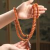 108-bead Buddhist mala, honey-colored prayer beads, natural seed necklace, meditation necklace, spiritual protection pendant, eye motif mala, handmade Buddhist jewelry, mindfulness accessory, Zen lifestyle gift, eco-friendly spiritual tool, unisex mala necklace, prayer beads for meditation, traditional mala design, earthy tone jewelry, calming energy beads, Buddhist ritual accessory, durable natural beads, minimalist spiritual wear, gift for yoga practitioners, authentic mala necklace.