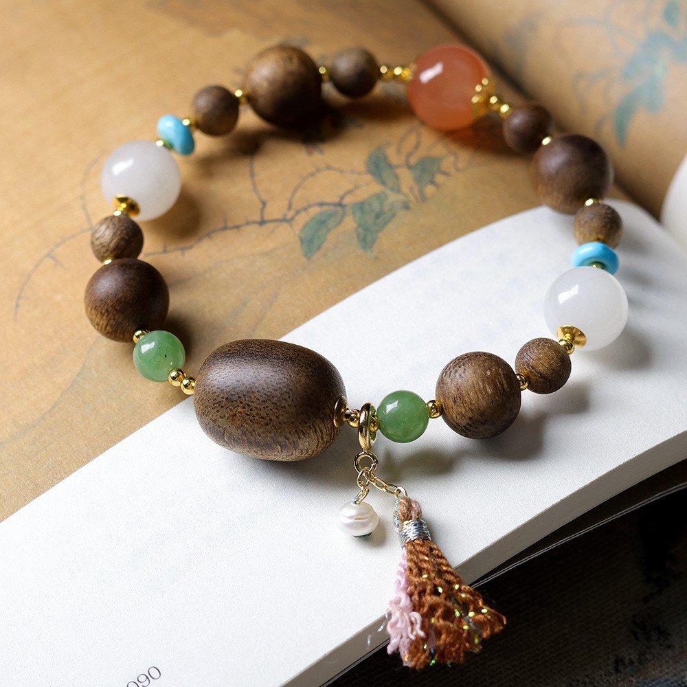 10mm Yellow Qinan agarwood bracelet, gemstone tassel jewelry, handmade spiritual bracelet, meditation agarwood beads, Yellow Qinan aromatic wood, turquoise jade aventurine combo, cultural artisanal jewelry, elastic-free knotting design, natural pearl tassel, holistic wellness accessory, ethical sourcing bracelet, luxury spiritual gift, daily mindfulness jewelry, grounding energy bracelet, symbolic gemstone meanings, artisan crafted mala, versatile layering bracelet, aromatic therapy jewelry, gender-neutral spiritual wear, eco-friendly materials. 