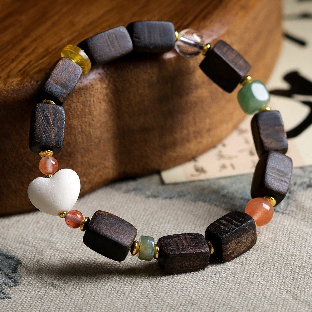 Dalan agarwood bracelet, 8-12mm wood beads, gemstone accent jewelry, natural aroma bracelet, handcrafted spiritual accessory, earthy tones bracelet, meditation wood beads, sustainable agarwood jewelry, rectangular bead design, gold-toned spacers, versatile stackable bracelet, ethical sourcing, calming fragrance beads, cultural heritage jewelry, holistic wellness accessory, unique gift idea, artisan crafted mala, daily mindfulness jewelry, organic texture design, eco-friendly materials.