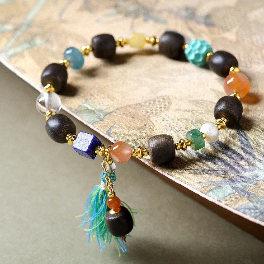 9mm White Qinan agarwood bracelet, Chinese-style spiritual jewelry, gemstone accent bracelet, tassel detail design, handmade cultural accessory, ethical agarwood sourcing, elastic-free knotting, natural aroma therapy, holistic wellness gift, bohemian elegance, meditation prayer beads, artisan crafted mala, versatile layering piece, eco-friendly materials, symbolic charm jewelry, luxury spiritual wear, positive energy accessory, unique gift idea, minimalist elegance, cultural symbolism. Temple consecration, house blessing, feng shui remedies, house pacification ceremonies, monk blessings, protective amulets, peace talismans, safety and peace assurance, wealth-invoking ceremonies, wealth deity statues, wealth-gathering formations, consecrated pi xiu (mythical creature), prayers and blessings, making vows, cultivating merit, peace and safety, imbuing objects with spiritual energy, infusing positive energy through sutra recitation, blessings, chanting mantras and dharani, liberation of deceased spirits, rebirth in the Pure Land, accumulating merit, nurturing compassion, devotional repentance, eliminating karmic obstacles, Buddha, Dharma, Sangha, portable guardian objects, peace-ensuring talismans, warding off evil spirits, neutralizing negative energies, averting disasters, deflecting misfortunes, Taiji and Bagua symbols. Buddhas: Dipamkara Buddha, Shakyamuni Buddha, Maitreya Buddha, Amitabha Buddha, Medicine Buddha, Akshobhya Buddha, Ratnasambhava Buddha, Amoghasiddhi Buddha, Five Dhyani Buddhas, Prabhutaratna Buddha. Bodhisattvas: Avalokiteshvara Bodhisattva, Manjushri Bodhisattva, Samantabhadra Bodhisattva, Ksitigarbha Bodhisattva, Mahasthamaprapta Bodhisattva, Guanyin, Wenshu, Puxian, Dizang, Maitreya, Akashagarbha, Vajrapani, Sarvanivarana-Vishkambhin. 