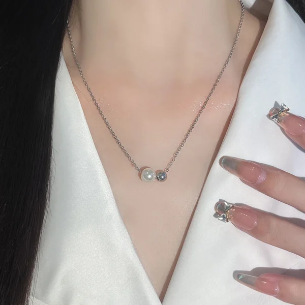 Titanium steel geometric necklace, imitation pearl jewelry, minimalist double-bead pendant, white gold tone chain, light luxury collarbone chain, adjustable necklace for women, hypoallergenic fashion jewelry, small luxury gifts, modern minimalist design, JUSONG KLEIN brand, sustainable materials, versatile daily wear, elegant gift idea, artisan crafted, positive energy accessory, cultural inspired design, holistic wellness jewelry, affordable luxury, niche fashion accessory, special occasion necklace.