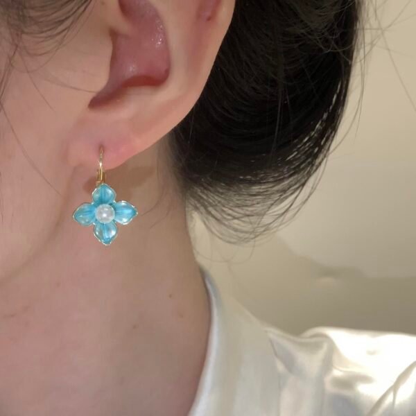 Sweet summer earrings, copper-alloy floral earrings, light blue glaze jewelry, pearl accent earrings, light luxury fashion earrings, versatile daily wear earrings, hypoallergenic ear accessories, nature-inspired design, gift for her, affordable luxury jewelry, nickel-free earrings, tarnish-resistant earrings, secure clutch earrings, feminine elegance earrings, seasonal summer accessories, wardrobe staple earrings, delicate floral motif, sophisticated pearl details, casual to formal earrings, artistic jewelry design.