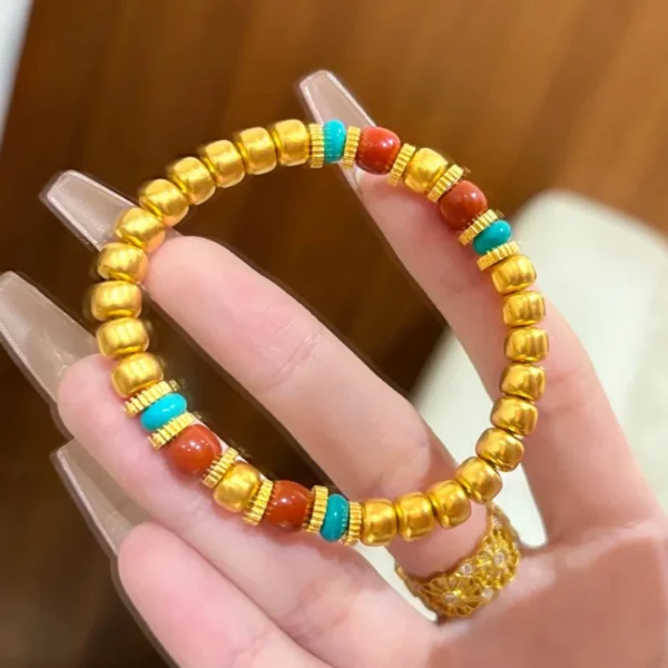 Hand Holding Gold Chinese Style Pumpkin Bead Bracelet with Red and Blue Beads