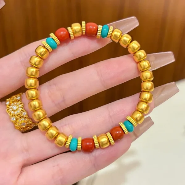 Hand Holding Gold Chinese Style Pumpkin Bead Bracelet with Red and Blue Beads