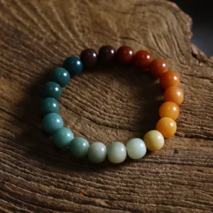 Gradient Color Bodhi Bracelet on Wooden Surface with Blue-Green to Orange-Yellow Beads