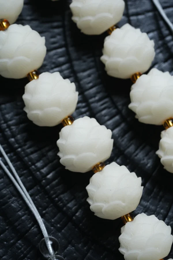 Lotus Mala Beads Arranged on Dark Textured Background