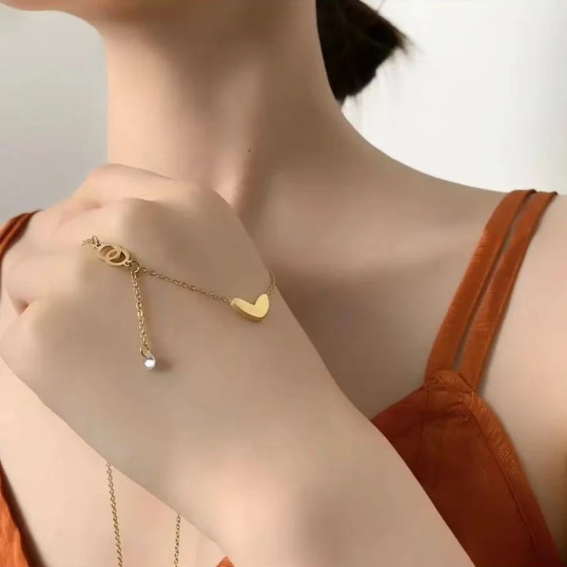 Gold-toned love heart necklace, titanium steel women's jewelry, double-sided pendant necklace, fade-proof adjustable chain, light luxury accessory, minimalist collarbone chain, hypoallergenic necklace, fashionable gift idea, versatile daily wear, sustainable materials, affordable elegance, artisan crafted, positive energy jewelry, modern feminine style, special occasion gift, holistic wellness accessory, cultural inspired design, elegant packaging.