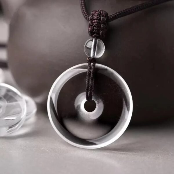 White crystal peace pendant, billion-year natural quartz, healing crystal jewelry, adjustable black cord necklace, minimalist spiritual accessory, energy balance pendant, artisan polished crystal, symbolic protection amulet, unisex crystal necklace, daily wear crystal jewelry, meaningful gift idea, Eastern culture inspired jewelry, Zen style pendant, holistic wellness accessory, natural quartz pendant, sleek crystal design, meditation jewelry, eco-friendly mineral gift, high-gloss finish crystal, timeless elegance jewelry.