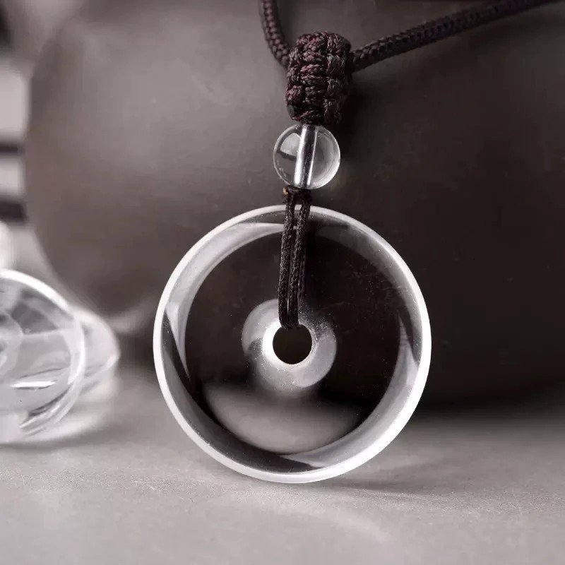 White crystal peace pendant, billion-year natural quartz, healing crystal jewelry, adjustable black cord necklace, minimalist spiritual accessory, energy balance pendant, artisan polished crystal, symbolic protection amulet, unisex crystal necklace, daily wear crystal jewelry, meaningful gift idea, Eastern culture inspired jewelry, Zen style pendant, holistic wellness accessory, natural quartz pendant, sleek crystal design, meditation jewelry, eco-friendly mineral gift, high-gloss finish crystal, timeless elegance jewelry.