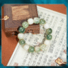Green Bodhi Barrel Bead Bracelet with White Jade Accents on Calligraphy Paper
