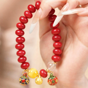 Hand Holding Red Bodhi Bracelet with Gold Charms and Yellow Bead