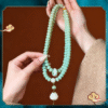 Hand Holding Celadon Bodhi Mala with White Lotus Pendant and Orange Beads