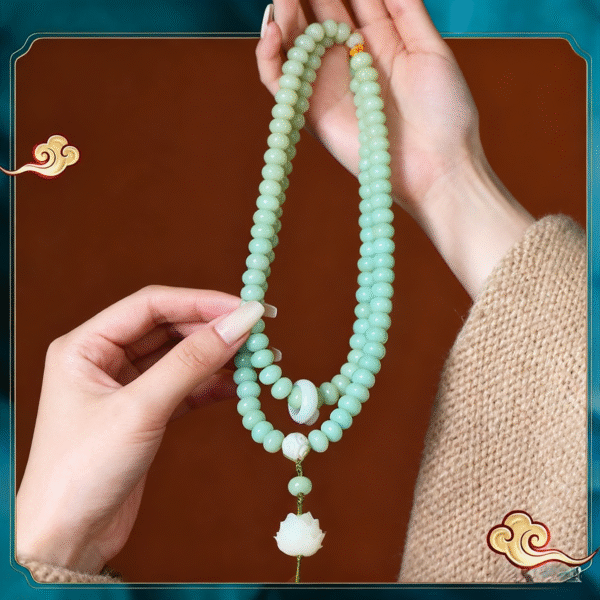 Hand Holding Celadon Bodhi Mala with White Lotus Pendant and Orange Beads