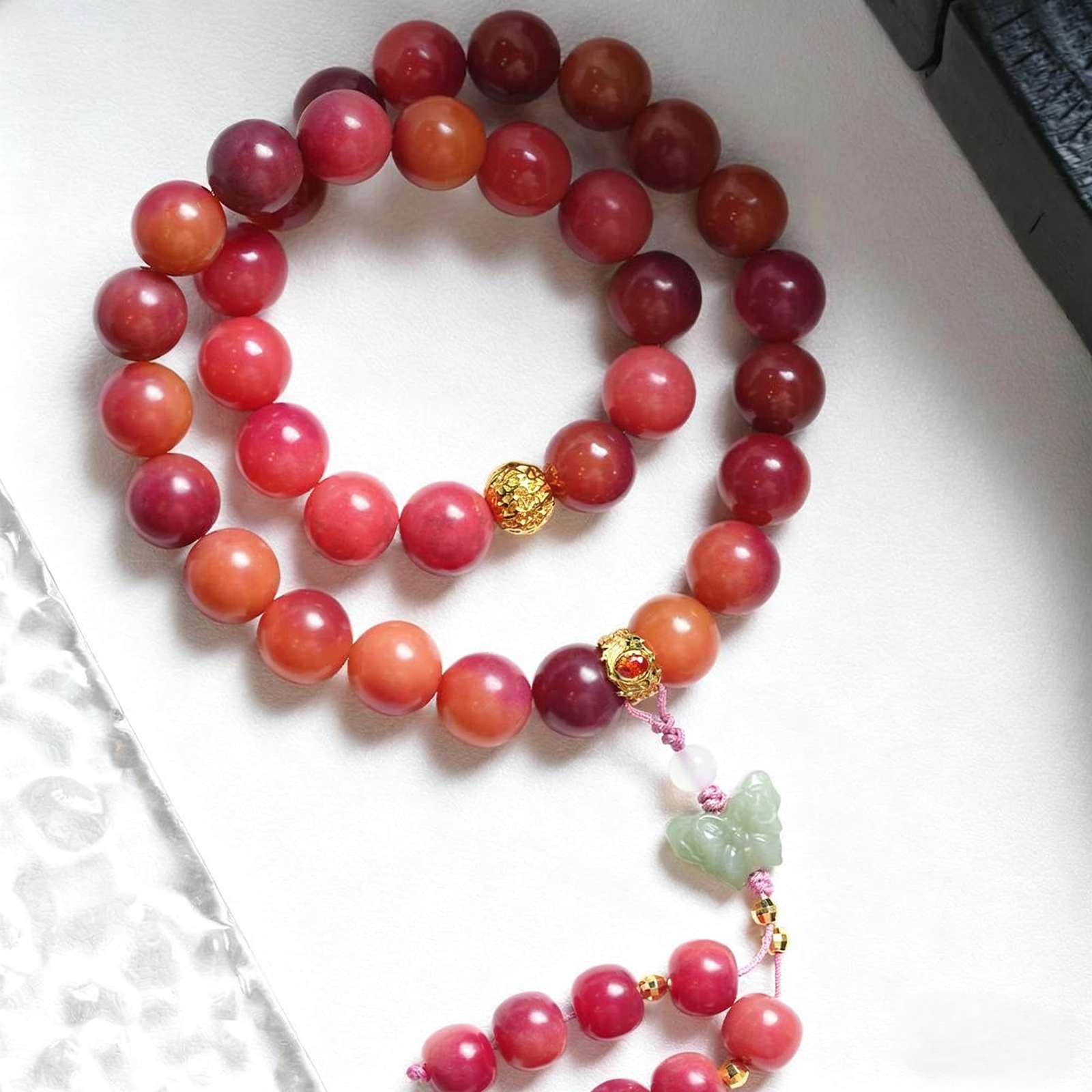 Arm Wearing Chinese Style Pink Bodhi Bracelet with Fan Background