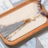 Smoky Amethyst Bodhi Bracelet with Butterfly Fairy Charm on Wooden Tray