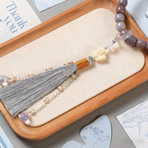Smoky Amethyst Bodhi Bracelet with Butterfly Fairy Charm on Wooden Tray