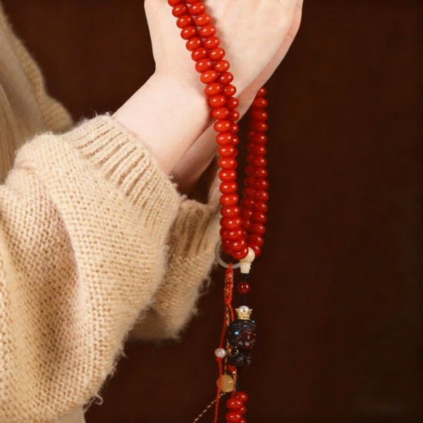 Two Hands Holding Red 108-Bead Bodhi Mala with Metal Accents