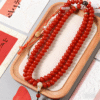 Red White Jade Bodhi Mala with Decorative Accents and Tassel on Wooden Tray