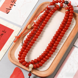 Red White Jade Bodhi Mala with Decorative Accents and Tassel on Wooden Tray