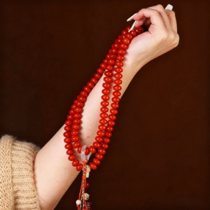 Close-up of Hand Holding Red Bodhi Mala with White Nails and Tara Charm