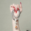 Hand Holding Smoky Grey Bodhi Bracelet with Lotus Charm and Calligraphy Scroll